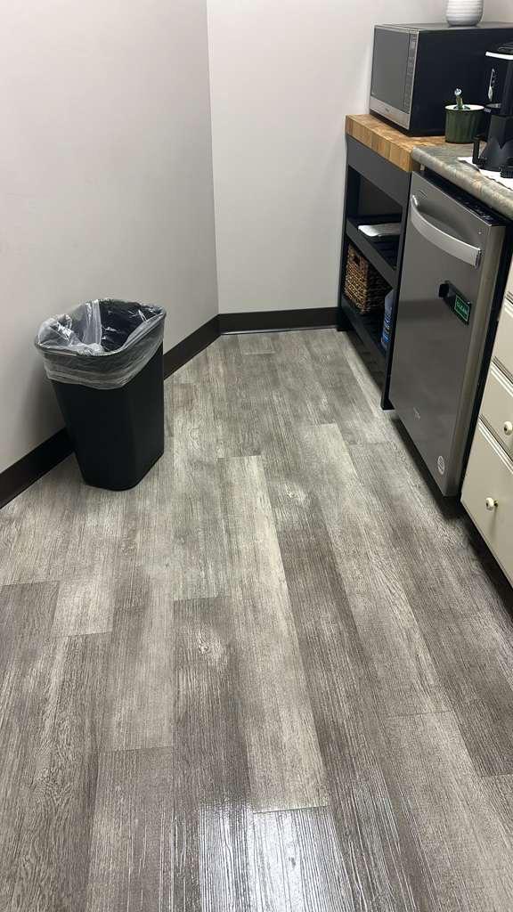 Office kitchenette with a lined wastebasket and clean-looking floor