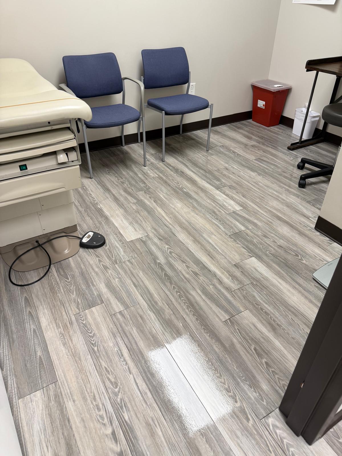 Blue visitor chairs and examination furniture in a room with gray flooring