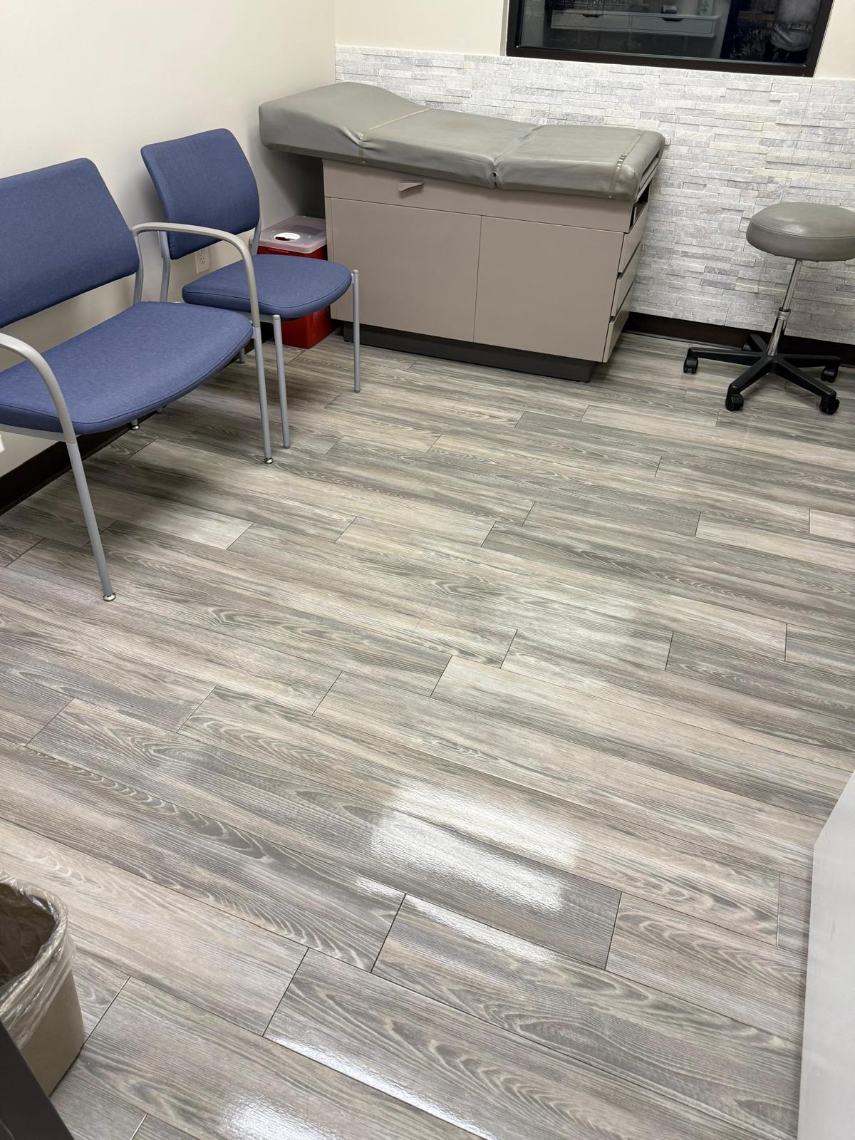 Exam room with chairs, examination table and wood-look flooring
